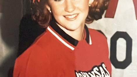 Tammie posing in her Arkansas High School cheerleading uniform in 1987.